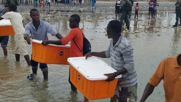 People in Haiti moving medical aid from Direct Relief to shore from a boat