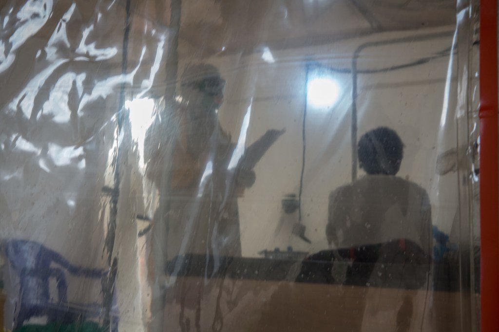 BENI, DEMOCRATIC REPUBLIC OF CONGO - A doctor wearing full protective gear speaks to a patient in the Ebola treatment centre in Beni, eastern Democratic Republic of the Congo.The DRC is currently experiencing the second worst Ebola outbreak in recorded history. (Photo by Sally Hayden/SOPA Images/LightRocket via Getty Images)
