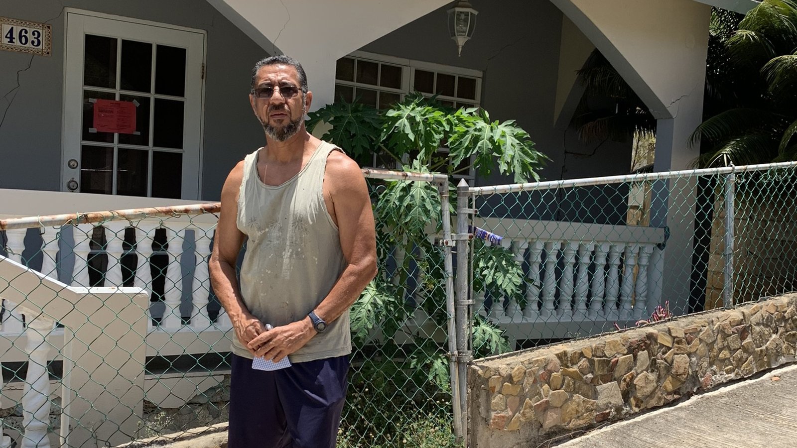William Ducós poses outside his damaged house. (Direct Relief photo)