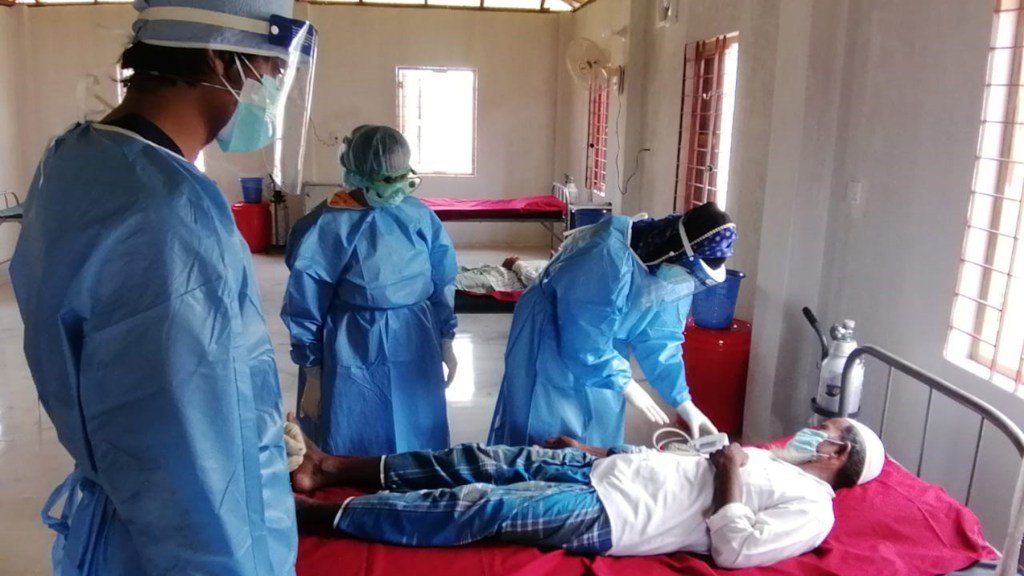 Staff members at the Covid-19 isolation center examine a patient. (Photo courtesy of HOPE for Bangladesh)